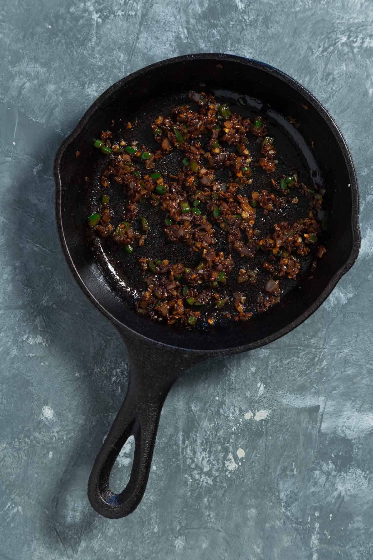 Sauteed shallot and jalapeno in a cast iron skillet