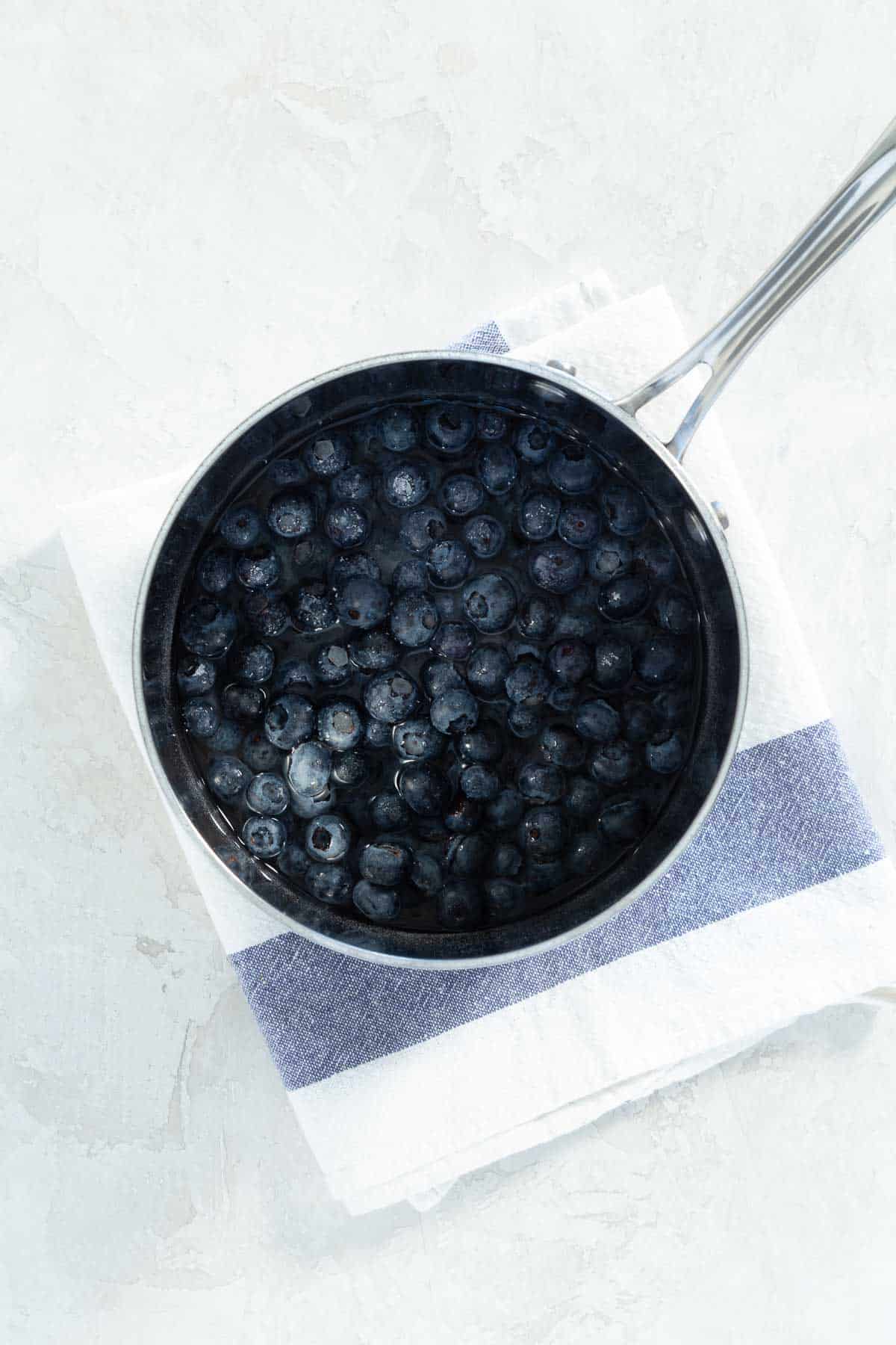 Pot with blueberries on a dish towel