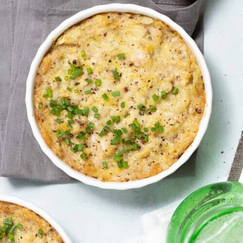 Overhead view of baked artichoke dip in a large white dish