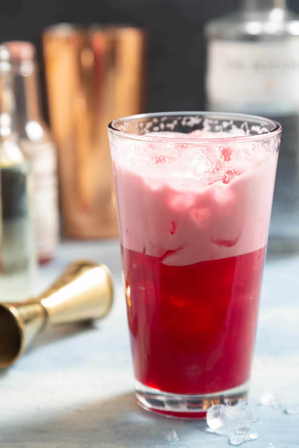 Closeup of a large glass with a pink foamy drink