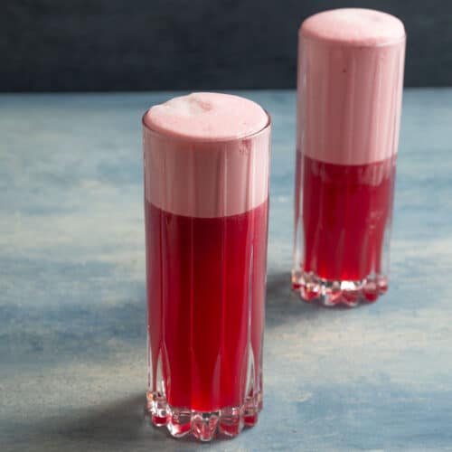 2 glasses holding a red foamy drink