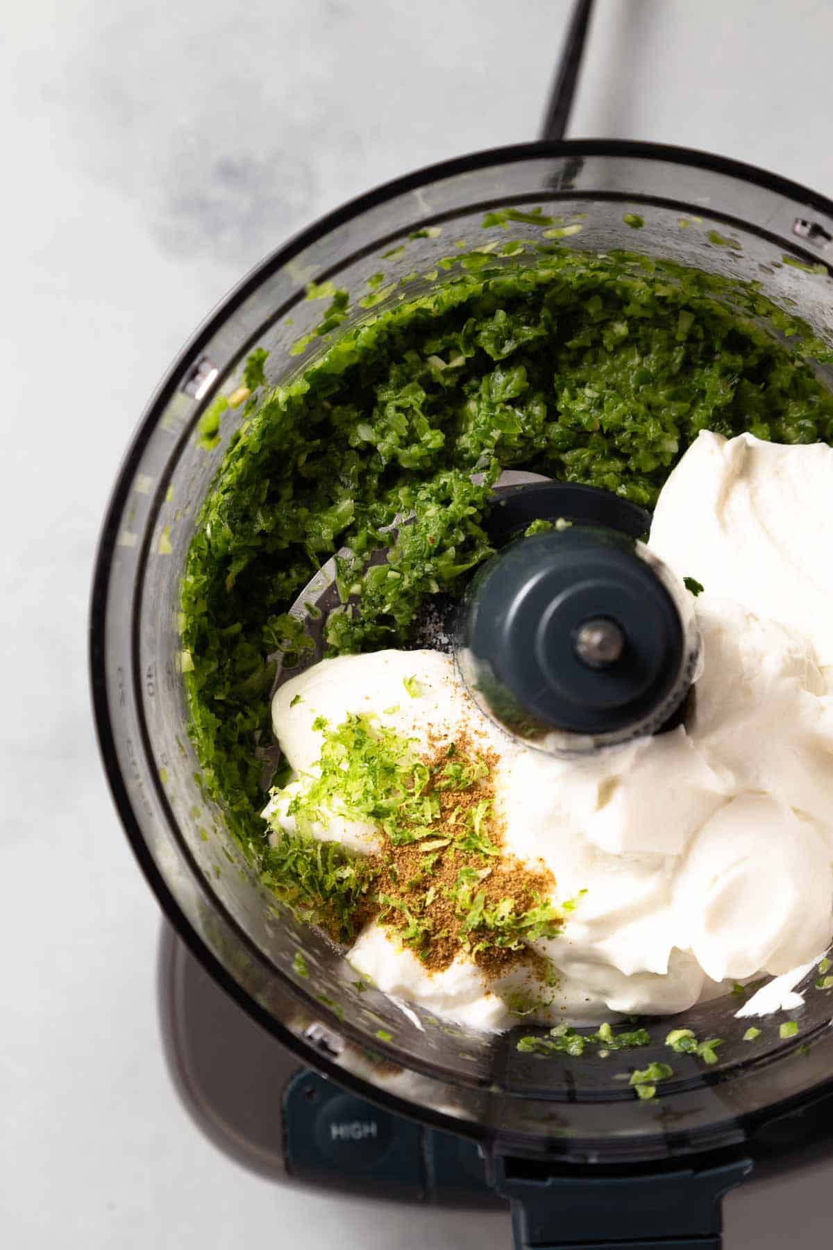 blended jalapenos and cilantro with seasonings and greek yogurt in a food processor