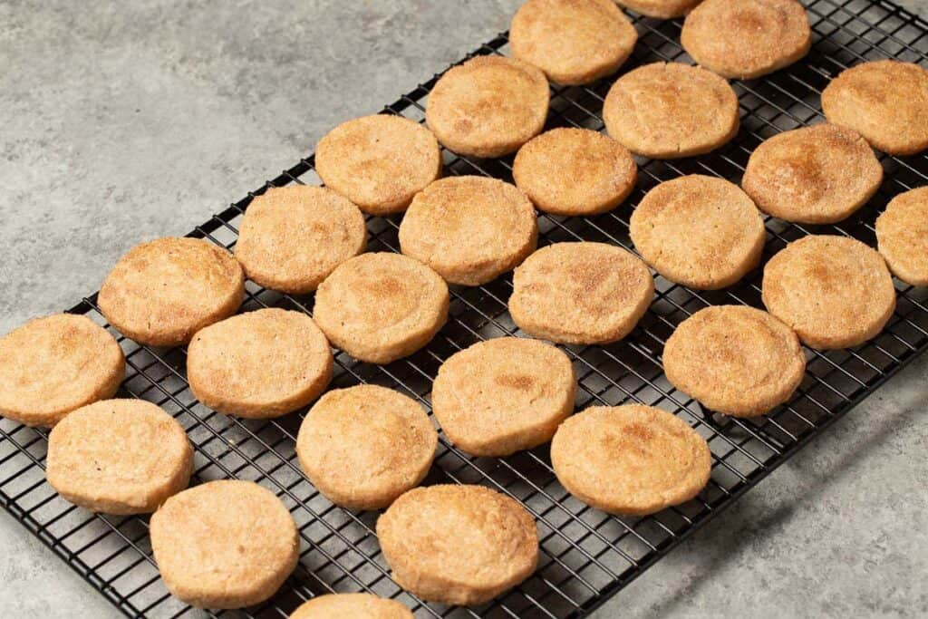 cinnamon and sugar coated shortbread cookies lined up on a black cooling rack