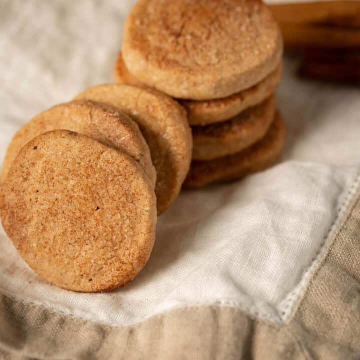 cinnamon coated shortbread cookies stacked on top of each other on a white linen napkin