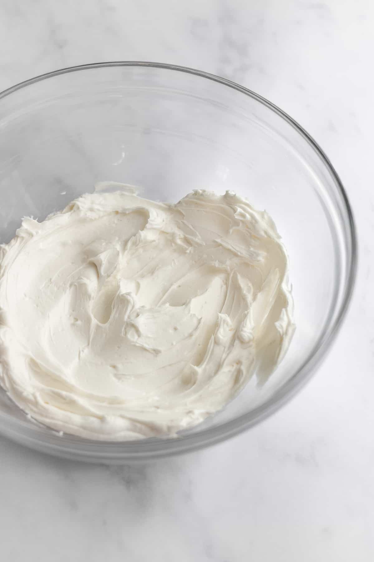 a glass bowl filled with whipped cream cheese