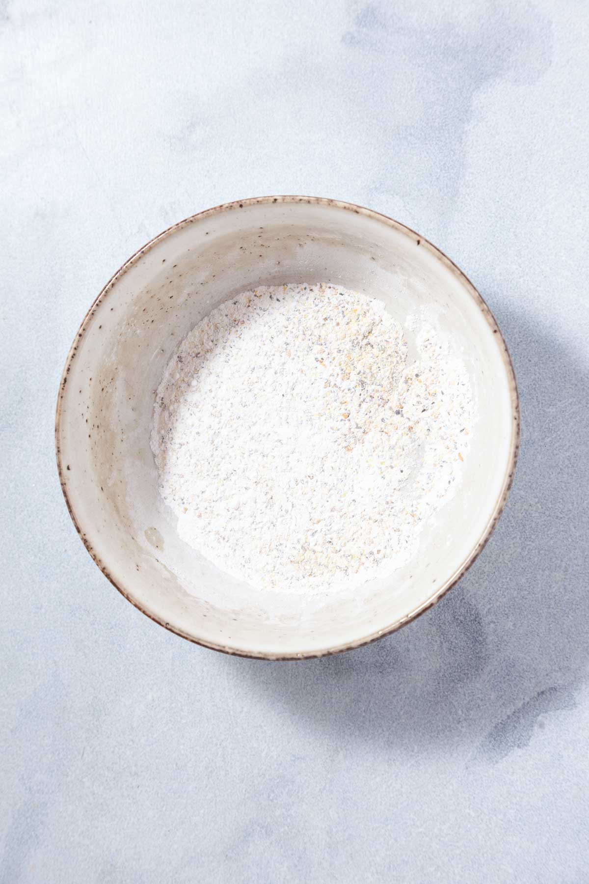a white bowl filled with seasonings and baking powder.