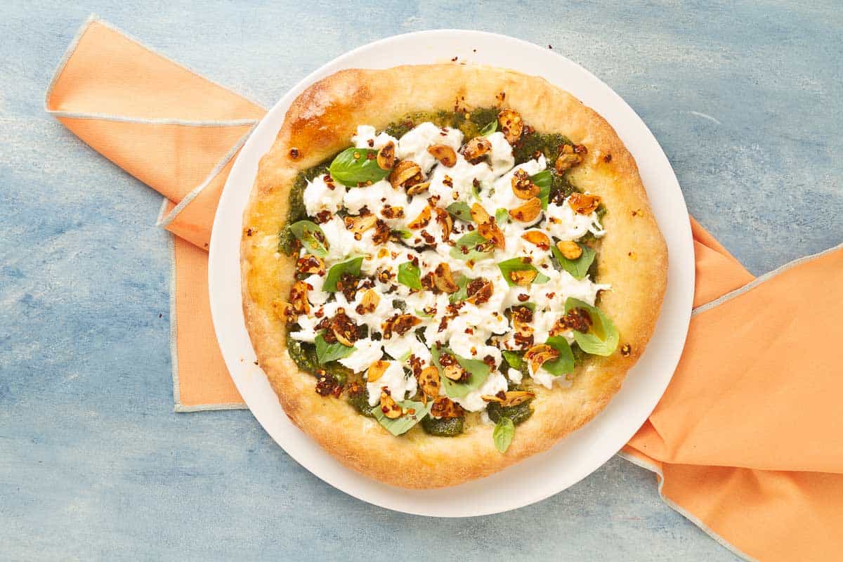 burrata pesto pizza on a white plate.